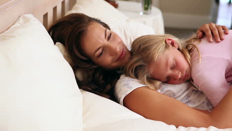 Mother-and-daughter-sleeping-together-in-bed