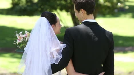 Happy-newlyweds-standing-in-the-park