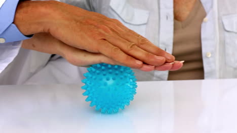 Doctor-explaining-a-massage-ball-to-patient