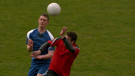 Football-players-jumping-up-and-tackling-for-the-ball