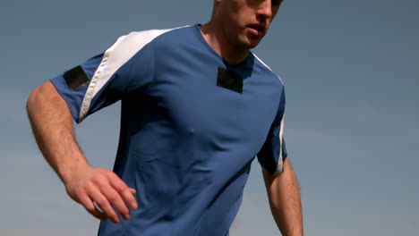 Football-player-running-under-blue-sky