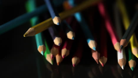 Colour-pencils-falling-on-black-surface