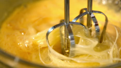 Whisk-in-glass-bowl-of-raw-egg