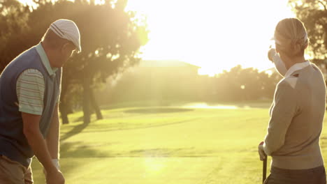 Happy-couple-teeing-off-at-the-golf-course