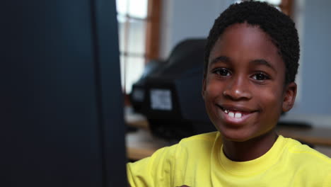 Kleiner-Junge-Lächelt-In-Die-Kamera-Während-Des-Computerunterrichts