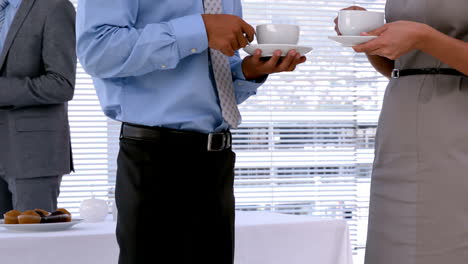 Business-people-standing-and-having-coffee