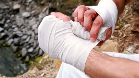 Fit-man-wrapping-hands-in-bandage