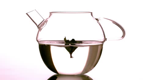Mint-leaf-falling-into-glass-teapot-