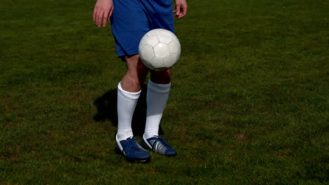 Jugador-De-Fútbol-En-Azul-Controlando-El-Balón-En-El-Campo.