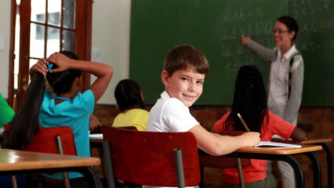 Little-boy-turning-to-smile-at-camera-during-class
