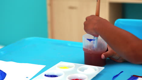 Cute-little-boys-painting-at-table-in-classroom