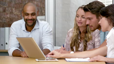 Casual-business-team-having-a-meeting-using-laptop