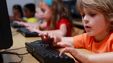 Little-boy-smiling-at-camera-during-computer-class
