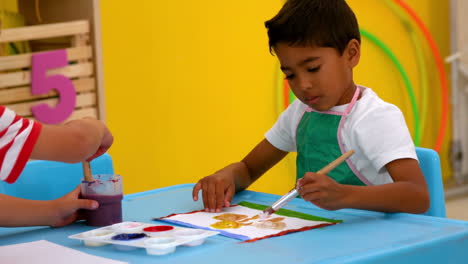 Lindos-Niños-Pequeños-Pintando-En-La-Mesa-En-El-Aula