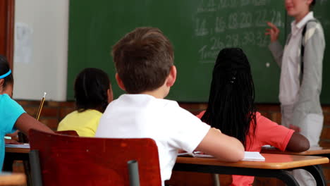 Pupils-listening-to-their-teacher-at-chalkboard