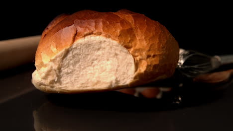 Loaf-of-bread-falling-on-black-background