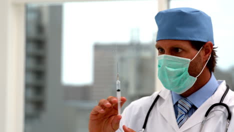 Doctor-in-mask-preparing-an-injection