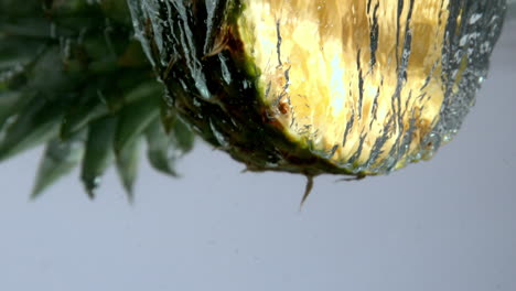 Ananashälfte-Fällt-Ins-Wasser-Auf-Weißem-Hintergrund