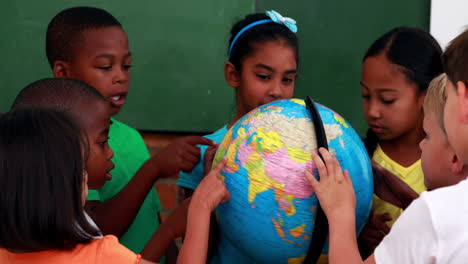 Pupils-looking-at-the-globe-in-classroom