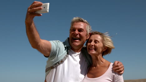 Senior-couple-taking-a-selfie-on-sunny-day