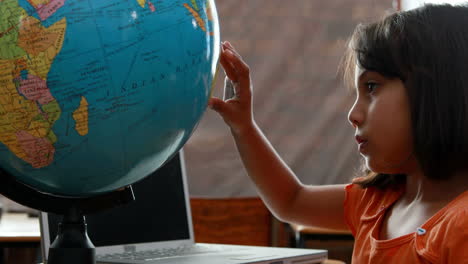 Kleines-Mädchen-Schaut-Im-Klassenzimmer-Auf-Den-Globus