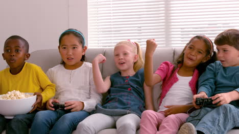 Süße-Kleine-Freunde-Sitzen-Zusammen-Auf-Der-Couch-Und-Spielen-Videospiele