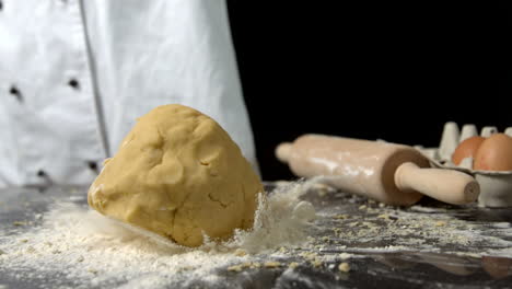 Chef-dropping-ball-of-dough-on-floury-surface