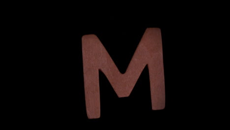 Der-Buchstabe-M-Steigt-Auf-Schwarzem-Hintergrund