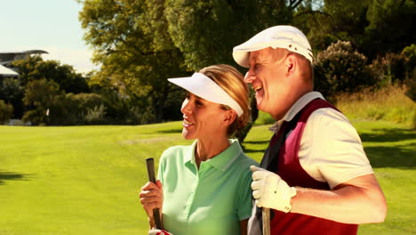 Couple-standing-on-the-golf-course-looking-ahead