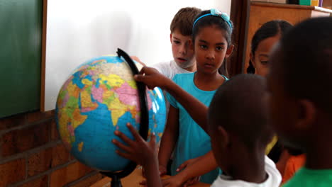 Schüler-Betrachten-Den-Globus-Im-Klassenzimmer