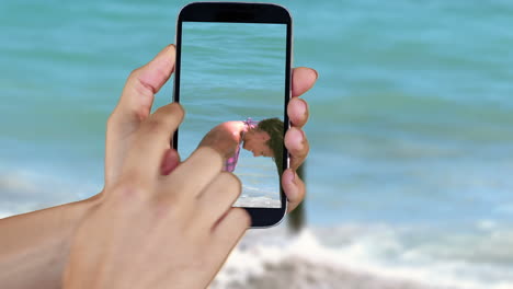 Hand-Zeigt-Strand--Und-Urlaubsclips-Auf-Smartphone