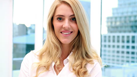 Pretty-blonde-businesswoman-smiling-at-camera