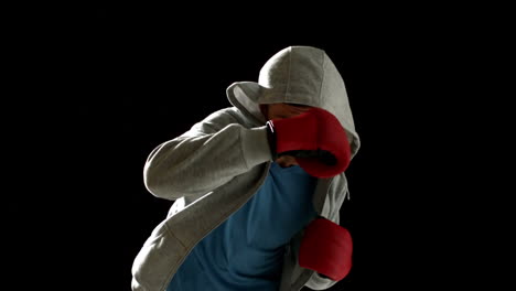 Fit-Mann-Stanzen-Mit-Boxhandschuhen-Auf-Schwarzem-Hintergrund