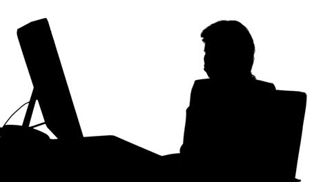 Businesswoman-filing-her-nails-at-her-desk-silhouette