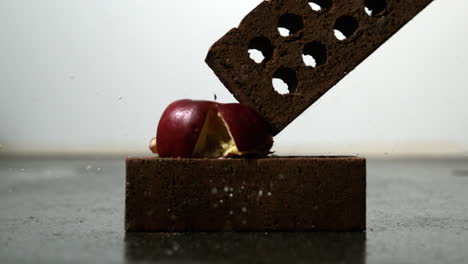 Apple-being-squashed-between-two-bricks