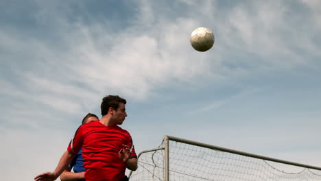 Jugadores-De-Fútbol-Saltando-Y-Atacando-El-Balón.