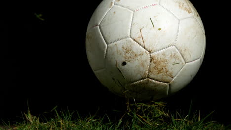 Dirty-football-bouncing-on-grass