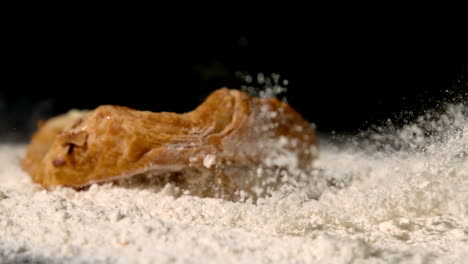 Gebäck-Snack-Fallen-Auf-Mehl-Auf-Schwarzem-Hintergrund