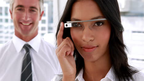 Businesswoman-smiling-at-camera-using-smart-glasses