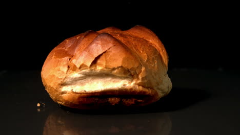 Loaf-of-bread-falling-on-black-background