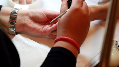 Nail-technician-giving-customer-a-manicure