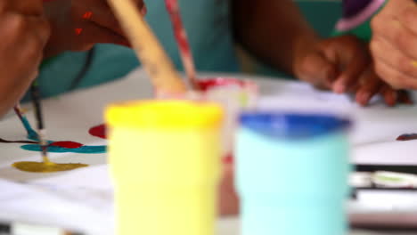 Preschool-class-painting-at-table-in-classroom