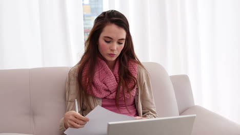 Pretty-brunette-using-laptop-on-the-couch