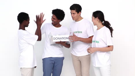 Feliz-Equipo-De-Voluntarios-Sosteniendo-Caja-De-Donación