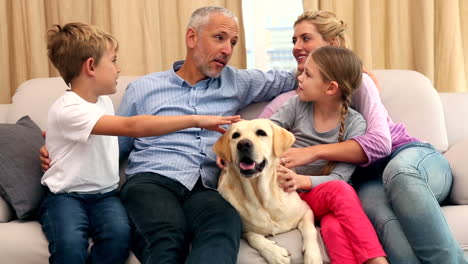 Happy-family-petting-labrador-on-couch