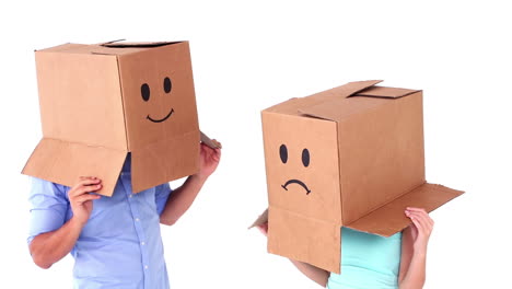 Junges-Paar-Trägt-Emoticon-Boxen-Auf-Dem-Kopf