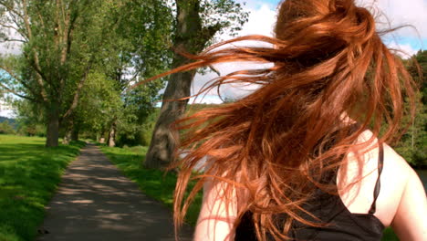 Fit-redhead-jogging-along-path-outside
