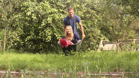 Attractive-young-couple-messing-around-with-wheelbarrow