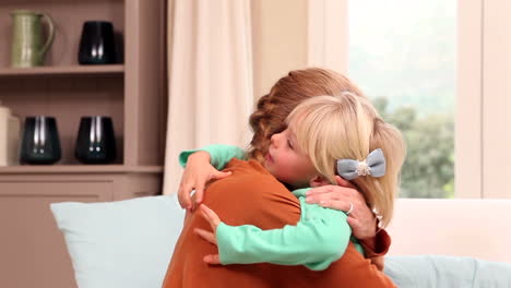 Cute-little-girl-hugging-her-mother-on-the-couch