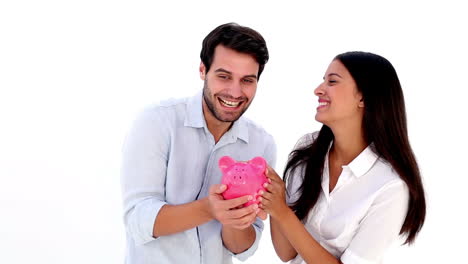 Attractive-young-couple-holding-piggy-bank